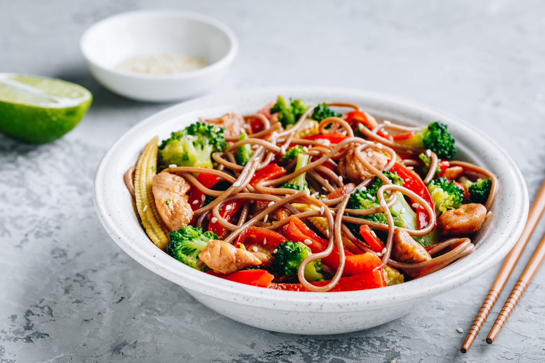 A stir-fried noodle bowl with chicken, broccoli and peppers